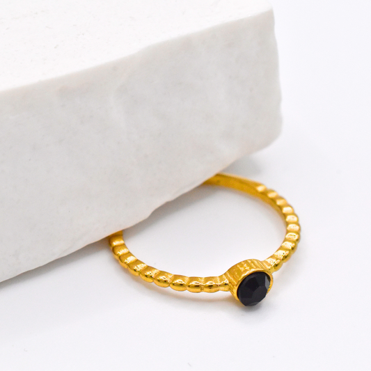 Bague modèle blacky en or et noire posée vue de près