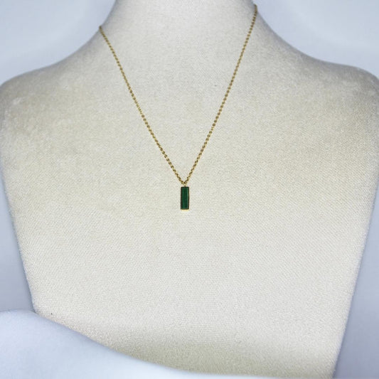 Collier modèle Loki Necklace en or avec pendant en pierre verte sur présentoir