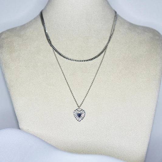 Collier modèle Love Is All Necklace en argent avec chaîne double (maille étroite et pendant coeur rayonnant) sur présentoir
