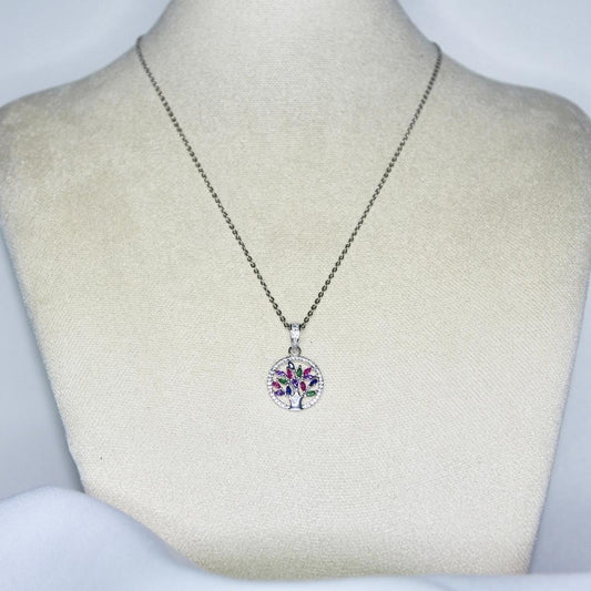 collier modèle Raise Necklace en argent avec pendant arbre de vie et pierres colorées sur présentoir