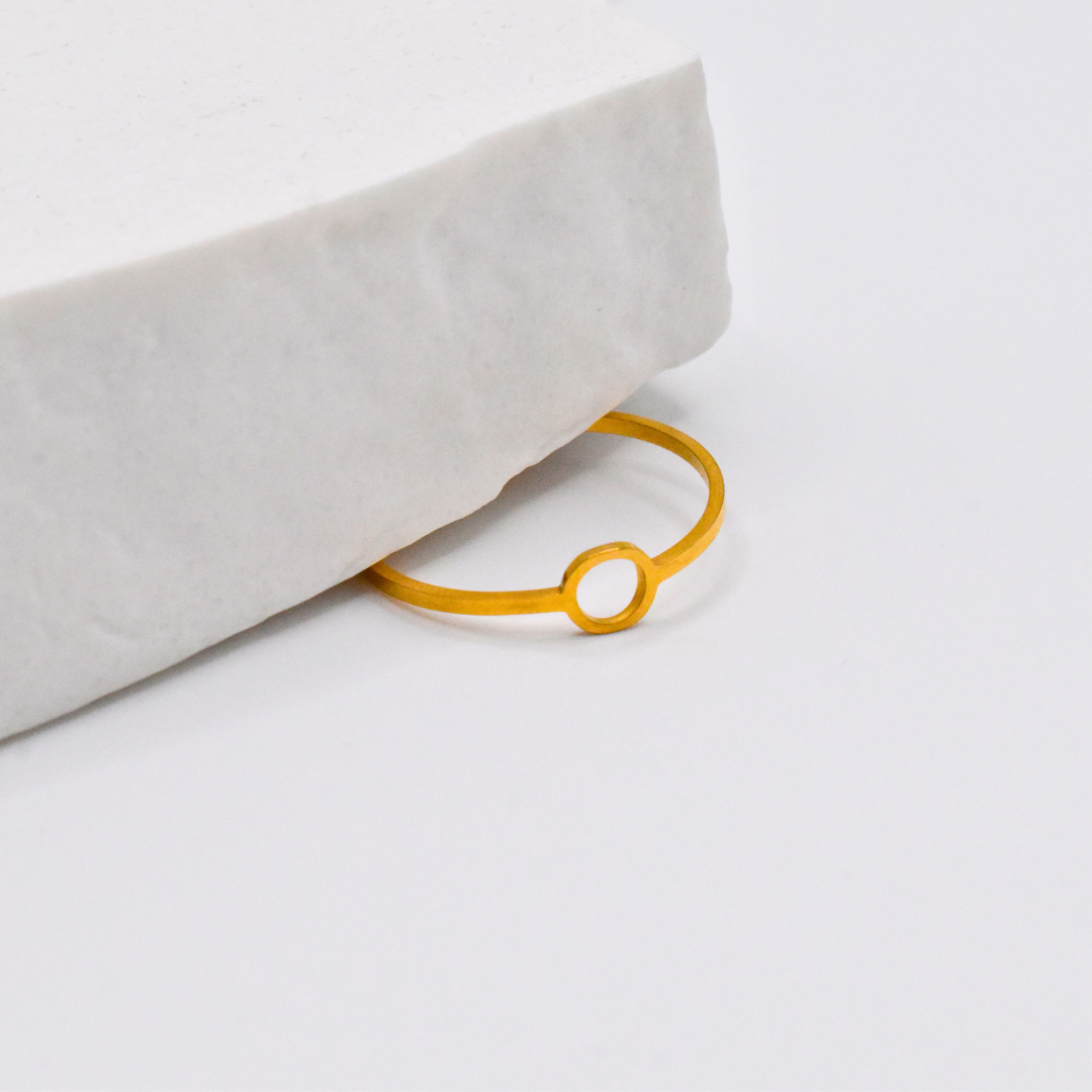 Bague modèle Circle Ring en or sous un support