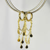 Boucles d'oreilles modèle Billie Earrings en or avec chaîne triple ornée de médaillons dorés sur présentoir