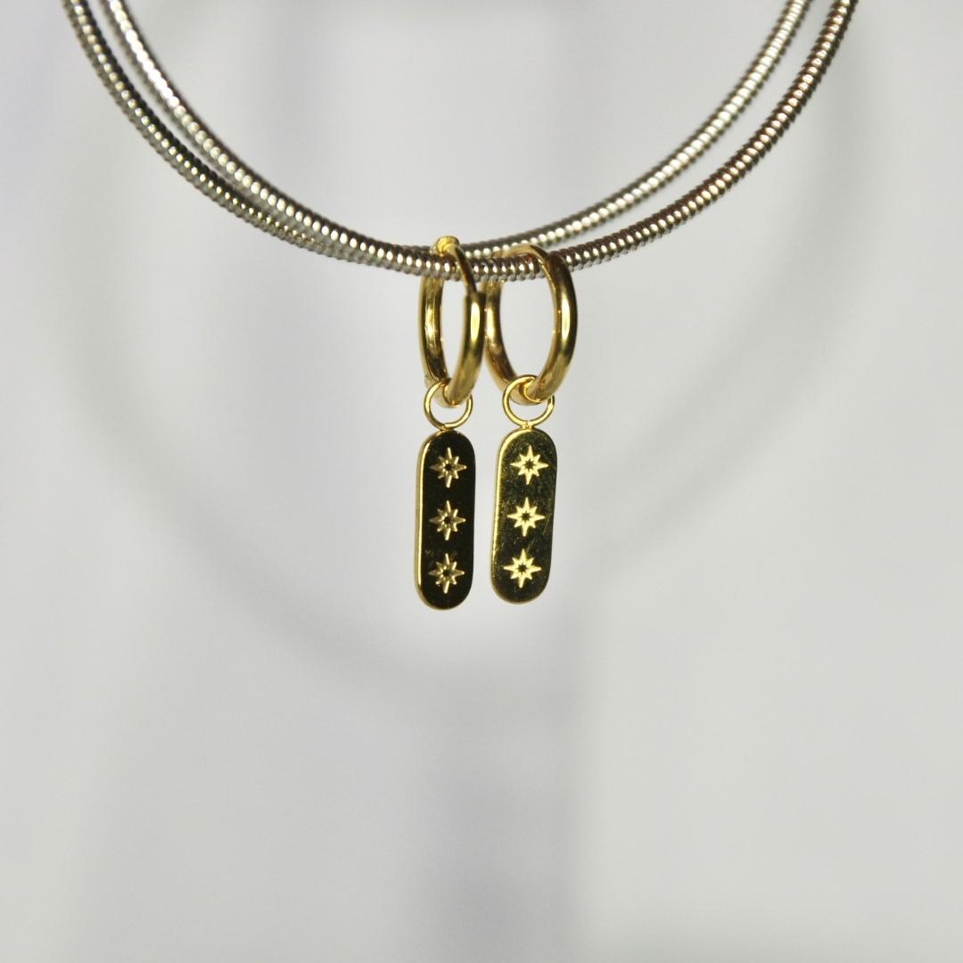 Boucles d'oreilles modèle Starlight Earrings en or avec pendant tablette gravée sur présentoir