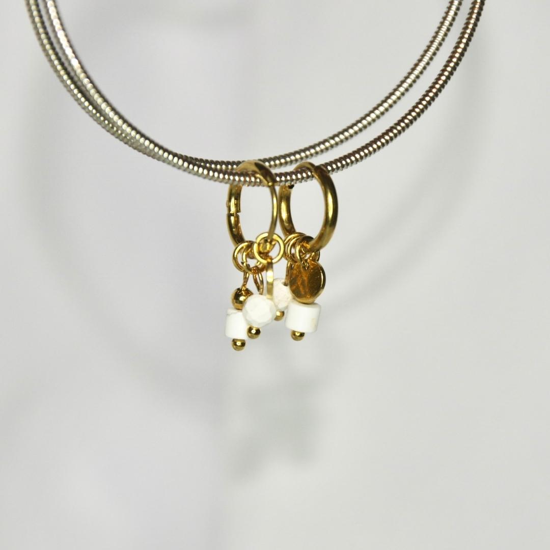 Boucles d'oreilles modèle Stone Earrings en or avec pendants pierres blanches sur présentoir
