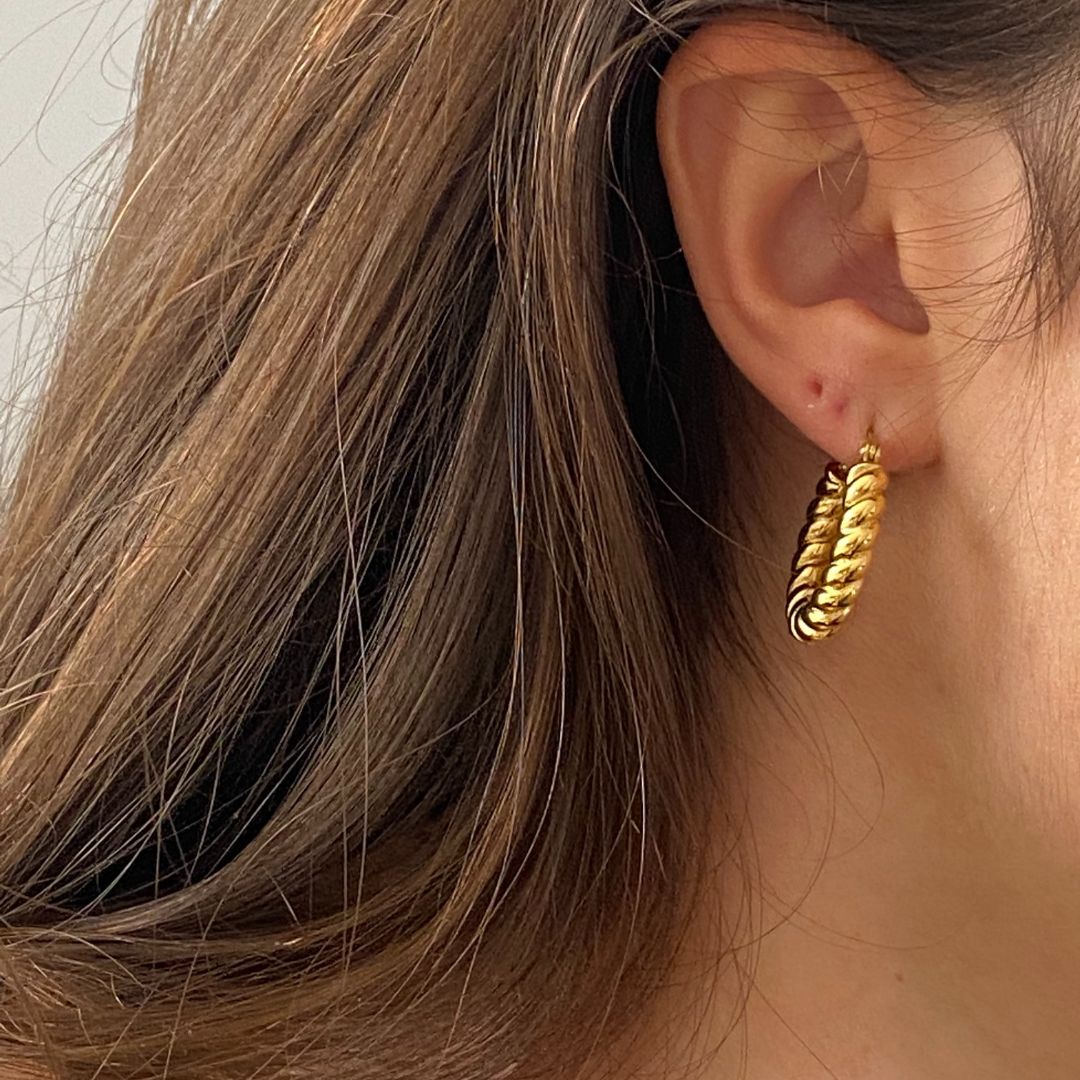 Boucles d'oreilles modèle embrace earrings en or portées