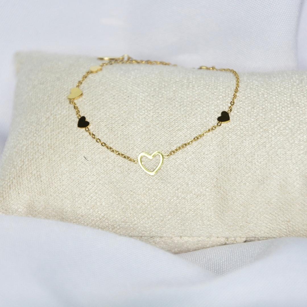 Bracelet modèle Attentions Bracelet en or avec pendants coeurs sur présentoir