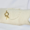 Bracelet modèle Cruise Bracelet avec fermoir bouée en or et chaîne en perles sur présentoir
