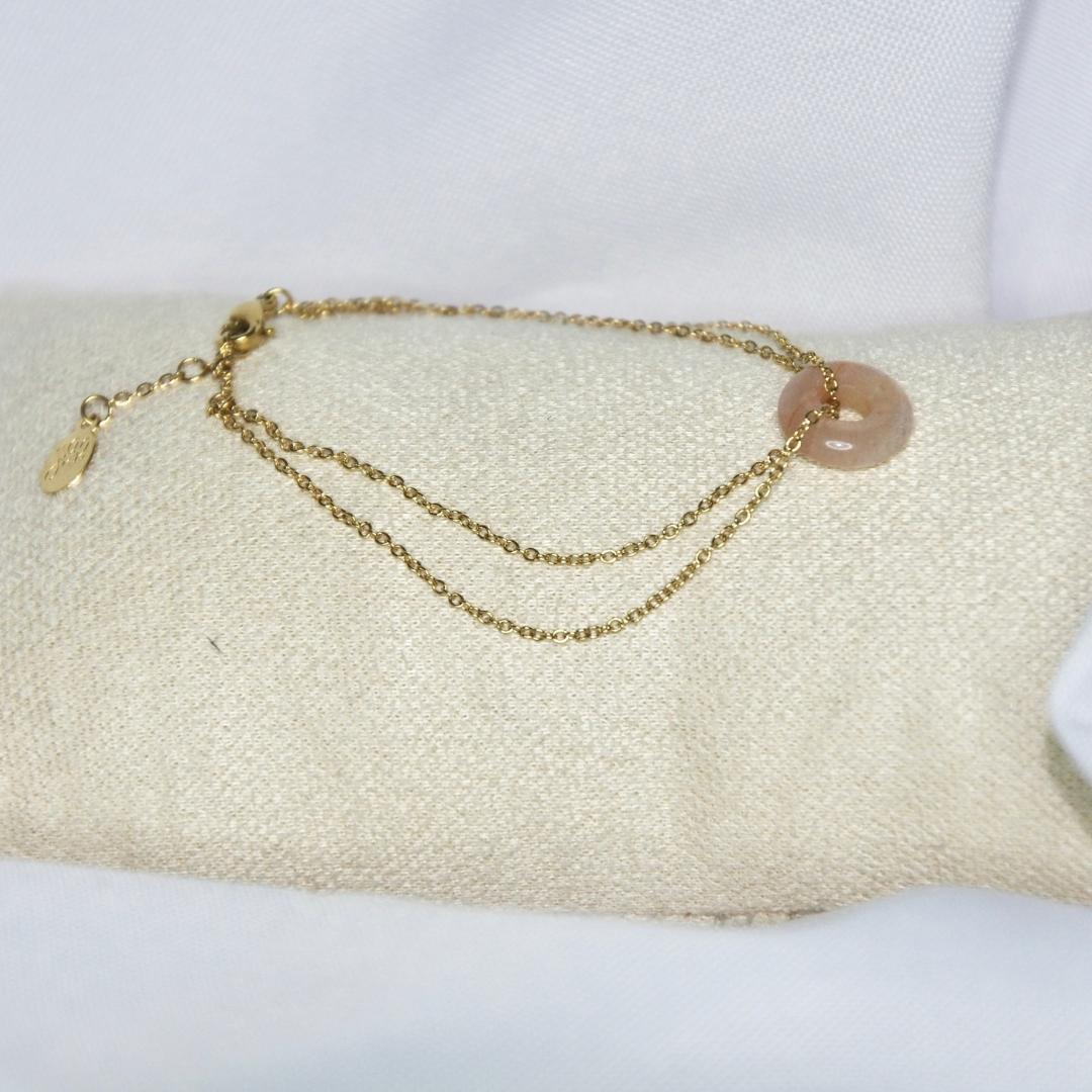 Bracelet modèle Donut Bracelet avec chaîne en or et pendant en pierre rose sur présentoir