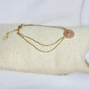 Bracelet modèle Donut Bracelet avec chaîne en or et pendant en pierre rose sur présentoir