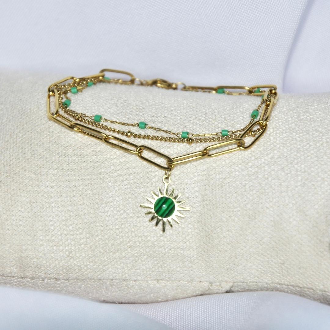 Bracelet modèle Mint Bracelet en or avec triple chaîne et détails verts sur présentoir