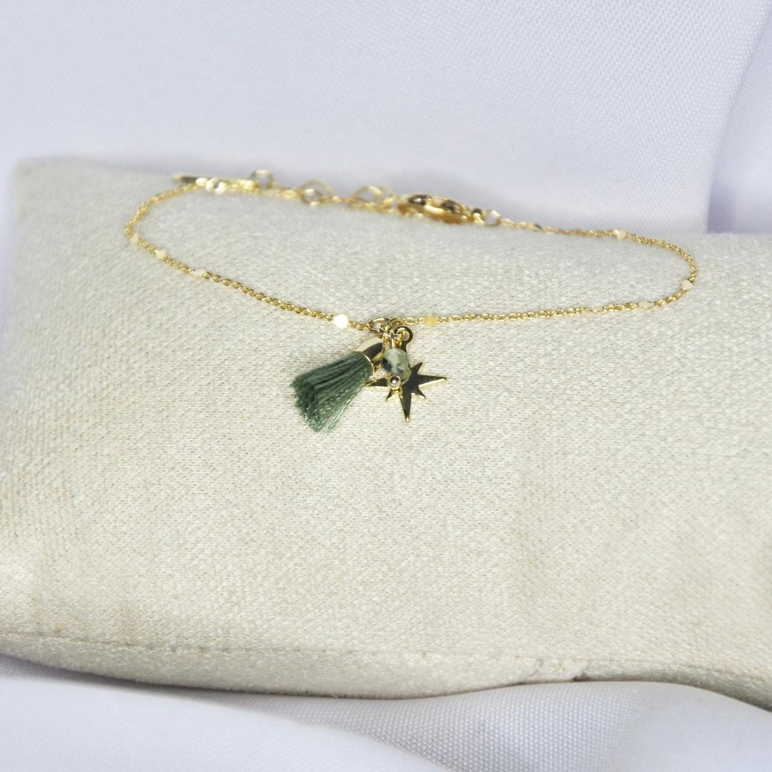 Bracelet modèle Spark Bracelet en or avec pompon vert et étoile sur présentoir