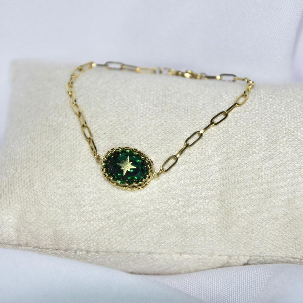 Bracelet modèle Theodora  en or avec pierre verte et étoile dorée sur présentoir