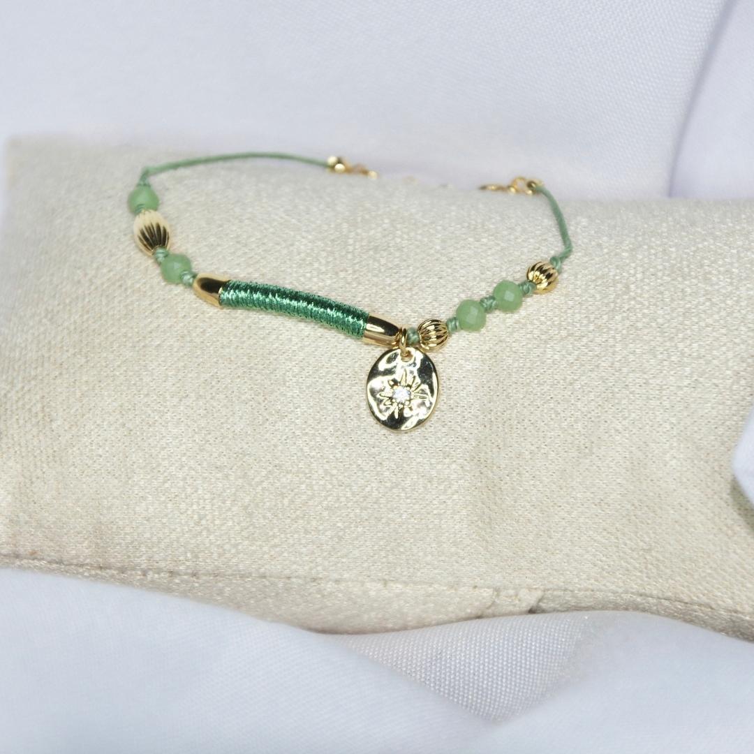 Bracelet modèle Wish Bracelet en or avec perles vertes et médaillon brillant sur présentoir