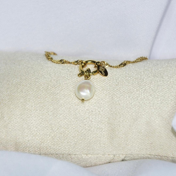 Charms modèle lagoon charms doré avec perle blanche nacrée sur présentoir