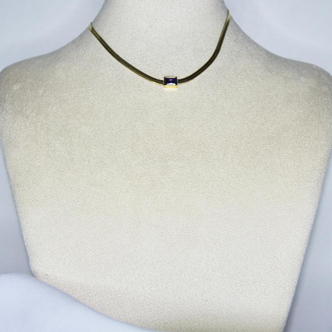 Collier modèle Empress Choker en maille serpent or et pierre violette sur présentoir