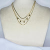 Collier modèle Famous Necklace en or triple chaîne (maille serpent, pendants étoile, grains de café) sur présentoir