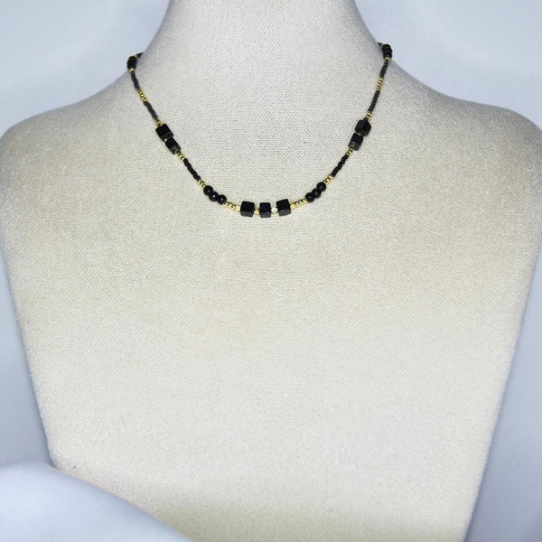Collier modèle Isle Necklace avec perles dorées et noires sur présentoir