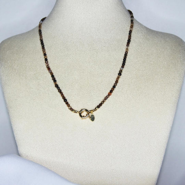Collier modèle La Ciotat Necklace en perles marrons avec fermoir bouée en or sur présentoir