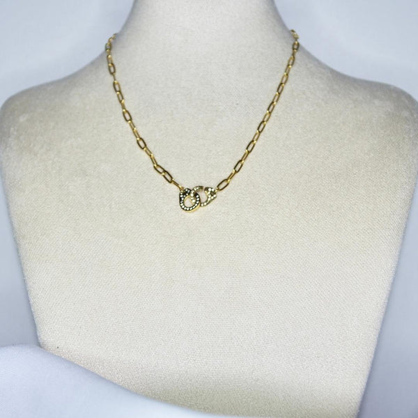 Collier modèle Linked Necklace en maille large or avec fermoir en forme de menottes et serti de strass sur présentoir